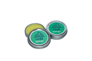Recovery Salve eco-friendly tins open to reveal muscle soothing balm inside. Green label on white background.