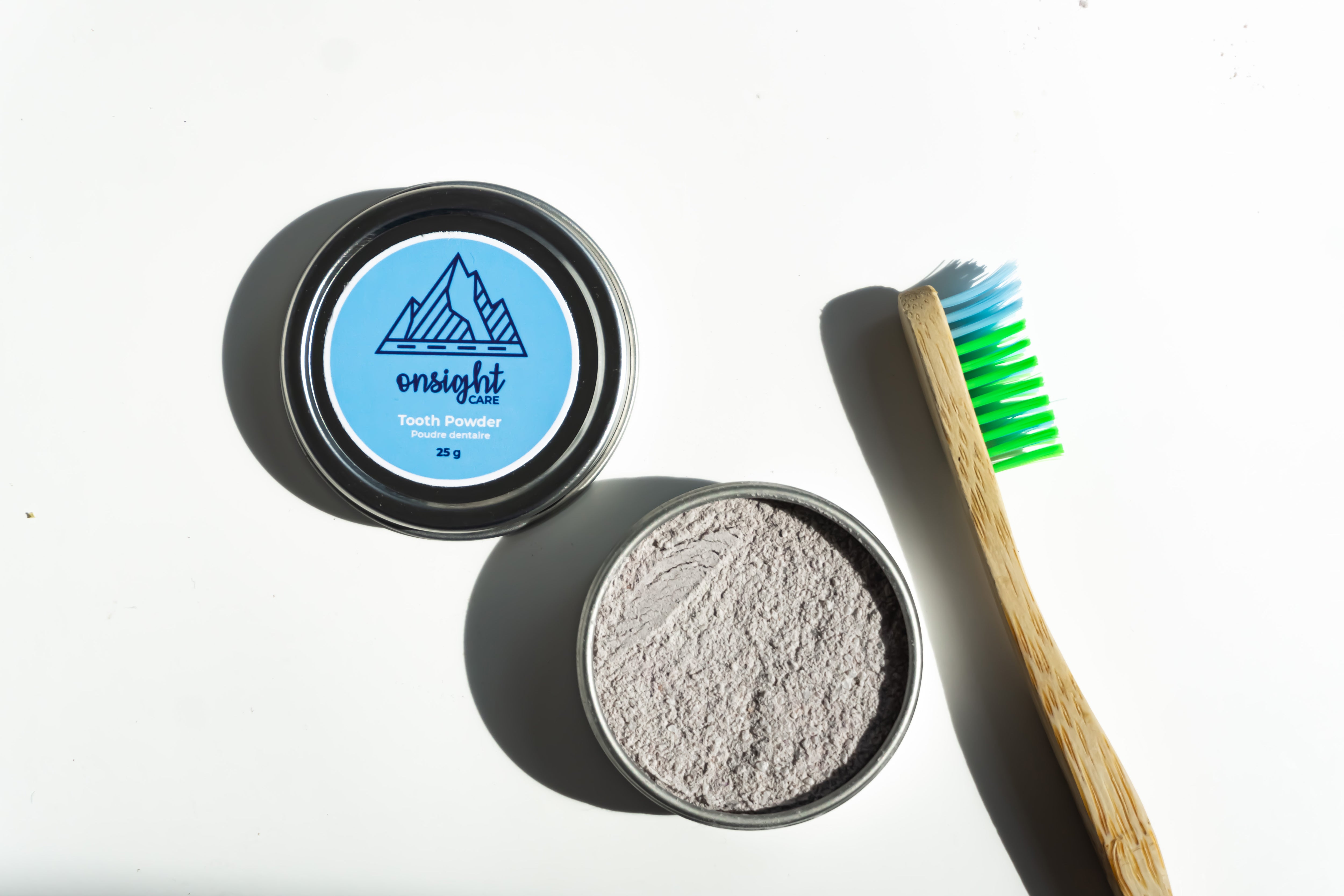 open spiced mint tooth powder tin with bamboo tooth brush beside.